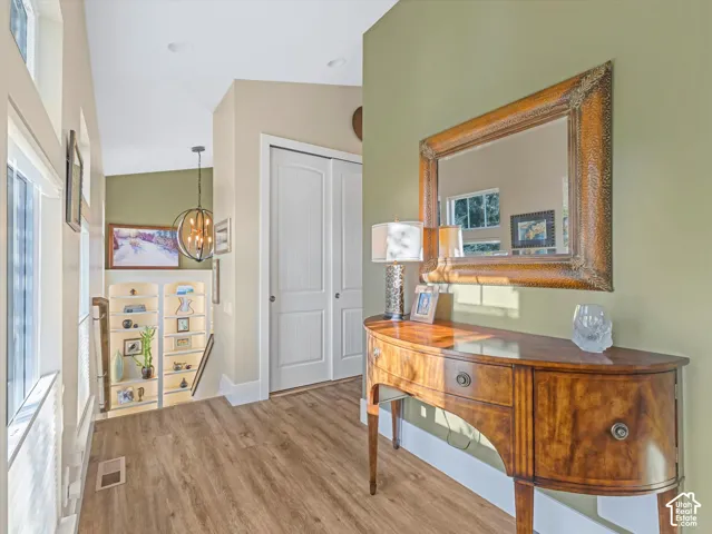 Hallway featuring a chandelier and light wood-style floors