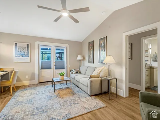 Living area with light wood-type flooring, vaulted ceiling, and ceiling fan