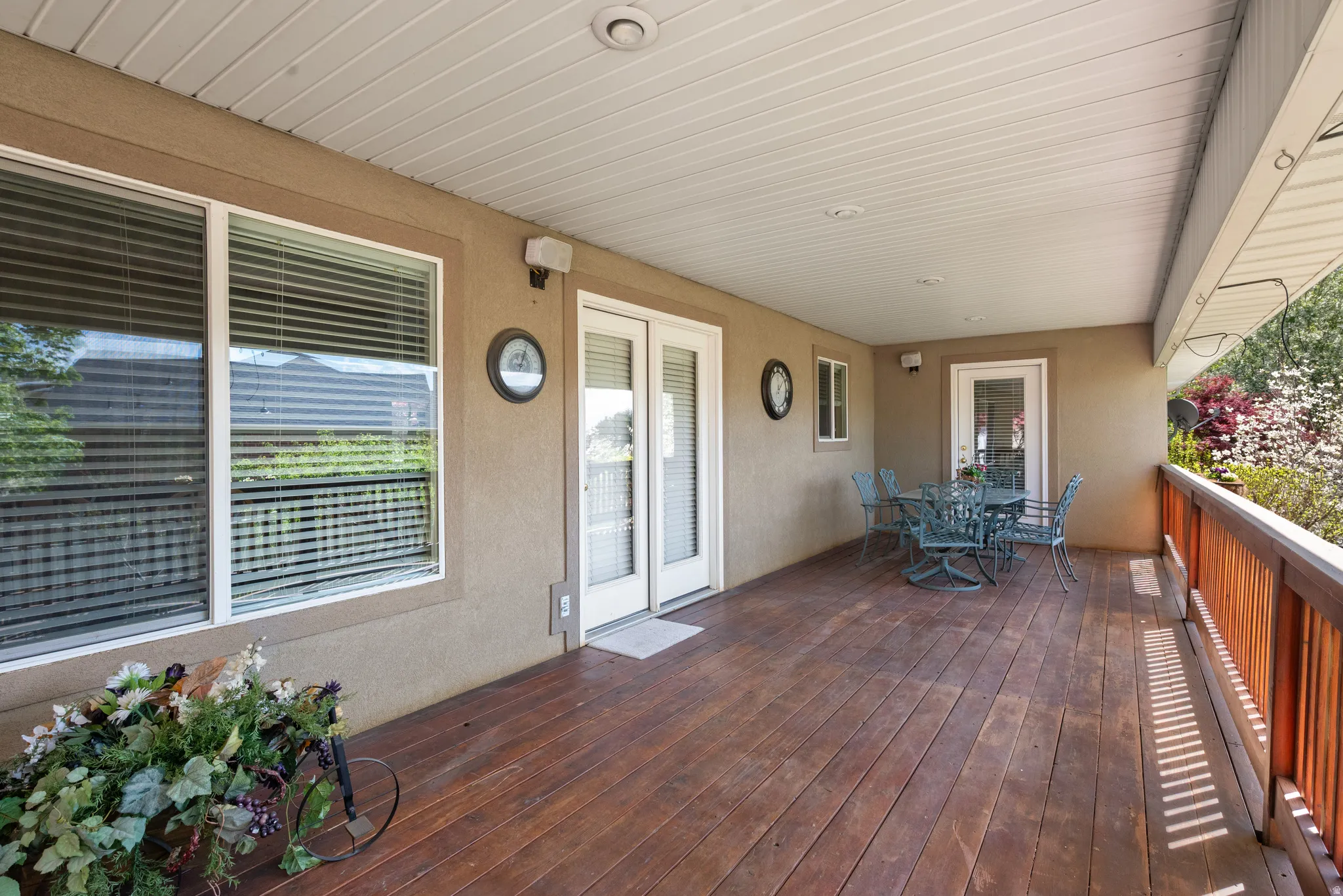 Spacious covered deck featuring wood-finish flooring, a wood railing, and recessed ceiling lighting