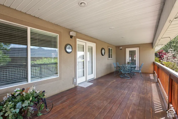 Spacious covered deck featuring wood-finish flooring, a wood railing, and recessed ceiling lighting
