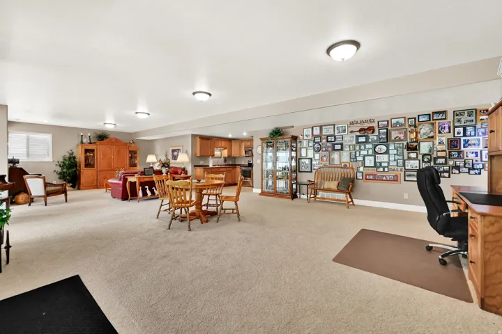 Open-concept lower level featuring neutral carpeting, recessed ceiling lighting, and a window for natural light