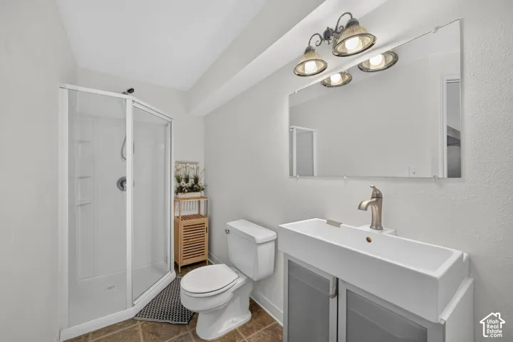 Bathroom featuring a glass-enclosed shower, a modern rectangular vessel sink, a wall-mounted mirror, and decorative vanity lighting