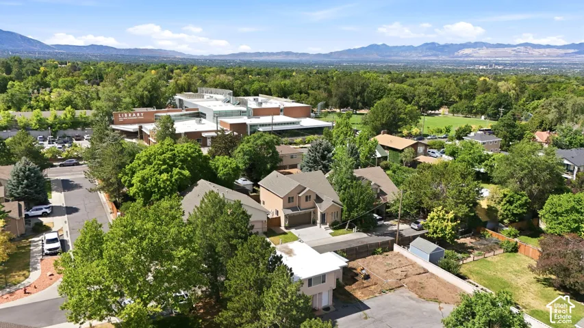 Suburban residential area with mature trees and mountain range backdrop