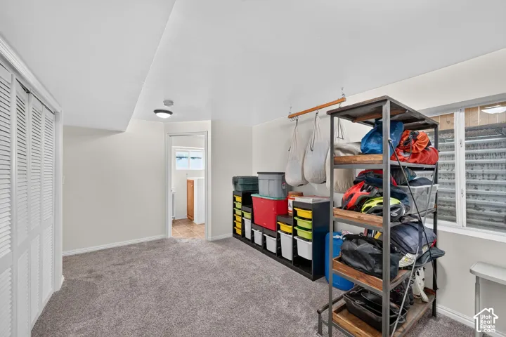 Spacious room featuring neutral carpet flooring and white walls