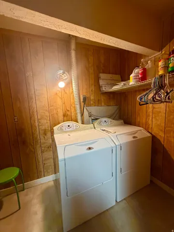 Utility area featuring wood paneling and a built-in wire shelf