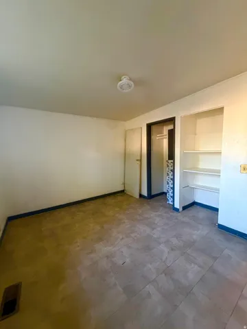 Room featuring light-toned flooring, white walls, and a ceiling-mounted light fixture