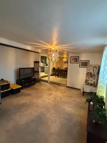 Spacious interior featuring wood-finish flooring, a contemporary ceiling light fixture, and a recessed dining area