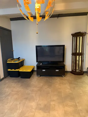 Room featuring light-toned flooring, white walls, and a dark grey trim