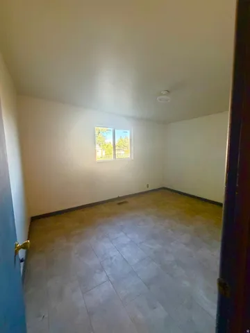 Room featuring light-toned walls, a rectangular window, and recessed ceiling lighting