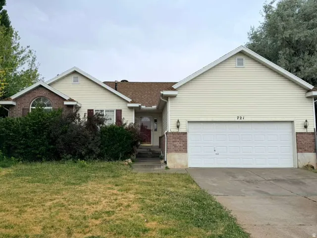 Exterior featuring a two-car garage, brick accents, and vinyl siding