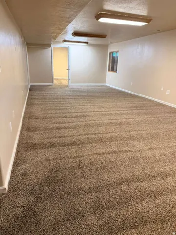 Spacious room featuring broadloom carpeting, neutral wall tones, and recessed lighting fixtures