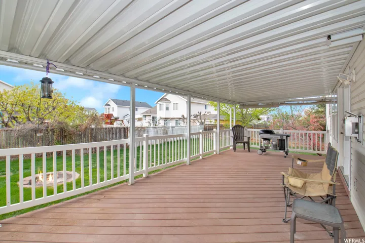 Expansive covered deck featuring wood-finish flooring and white railing