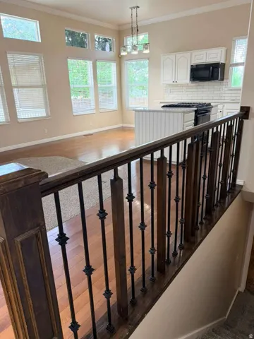 Staircase featuring dark wood handrails and wrought iron balusters