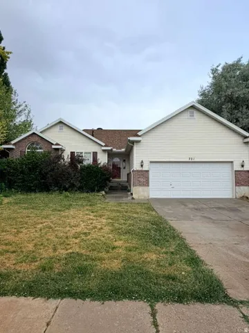 Ranch-style exterior featuring a two-car garage, brick accents, and a front entry with a transom window