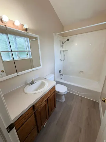 Bathroom with a single basin vanity featuring wood-finish cabinetry, a white countertop, and a mirrored medicine cabinet