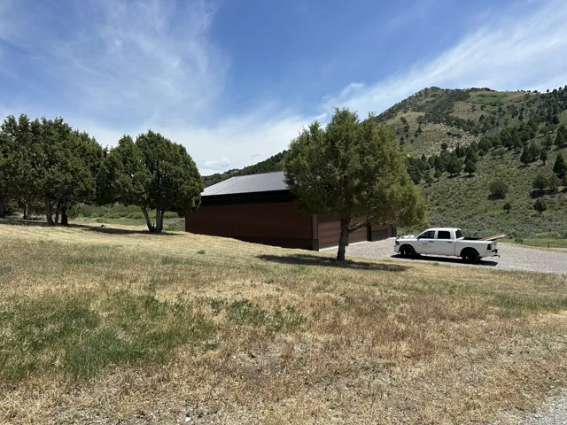 Modern structure featuring a brown exterior, dark roof, and multiple garage doors