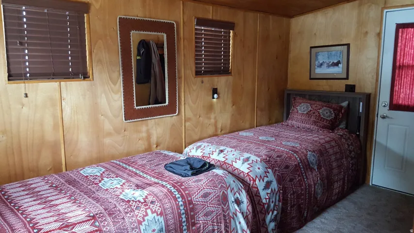 Wood paneling walls featuring two windows with horizontal blinds