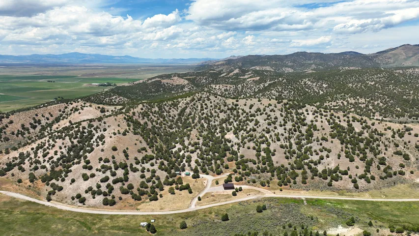 Expansive rural landscape featuring a mix of mountainous terrain and distant green fields