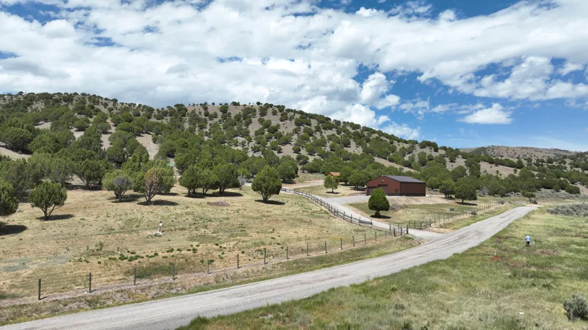 Expansive open space with a gravel driveway and split-rail fencing