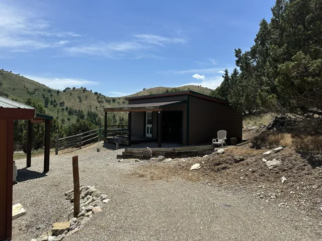 Wood-sided structure with covered porch and gravel driveway
