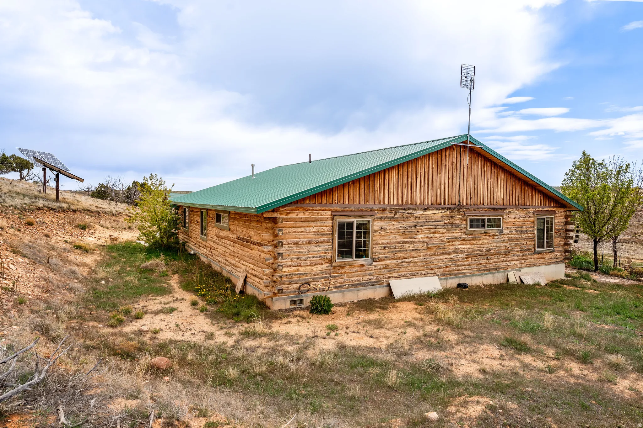 Log cabin style exterior with a green metal roof