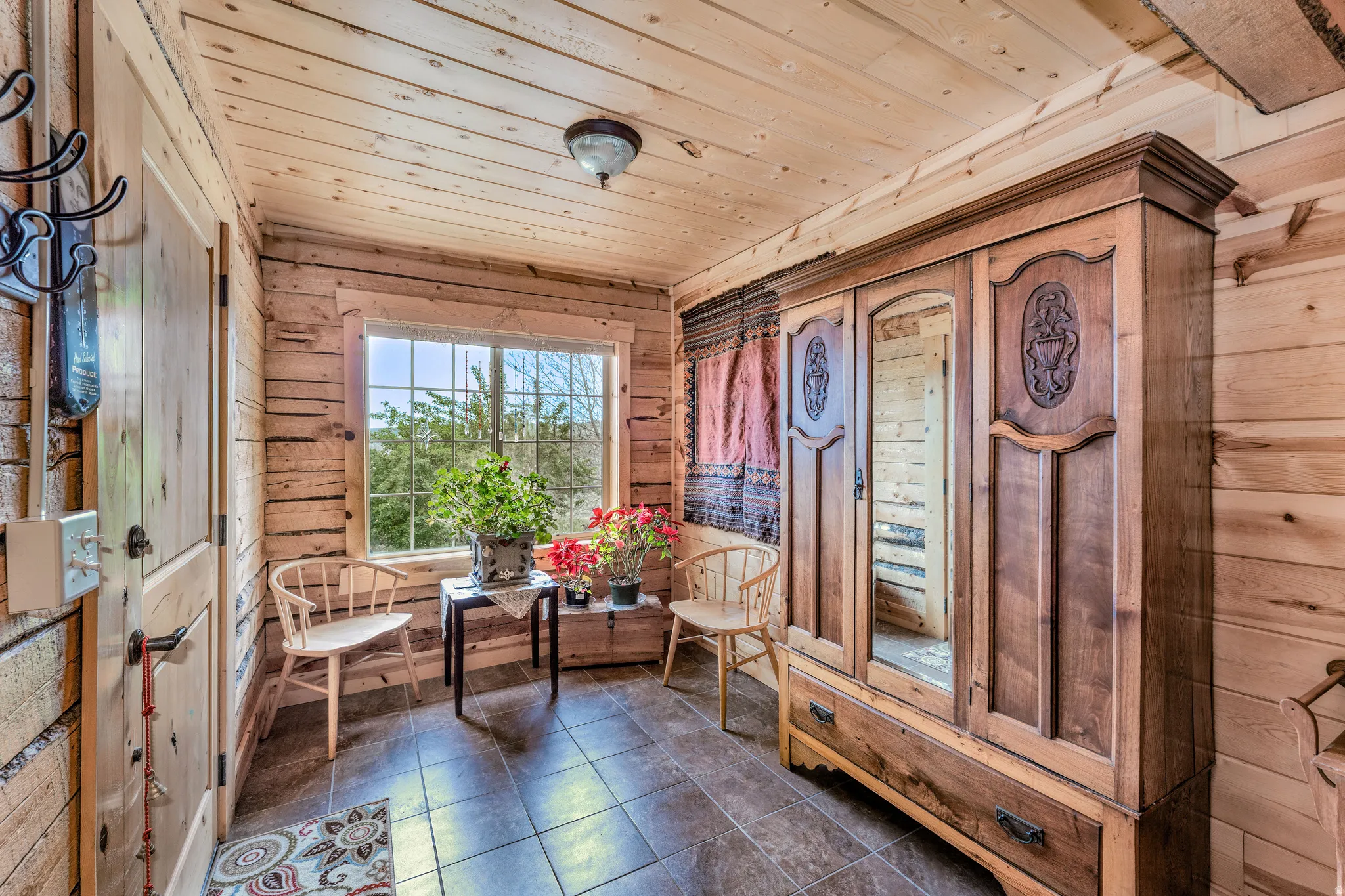 Entryway featuring wood-finish walls and ceiling, a large window, tiled flooring, and a solid wood door
