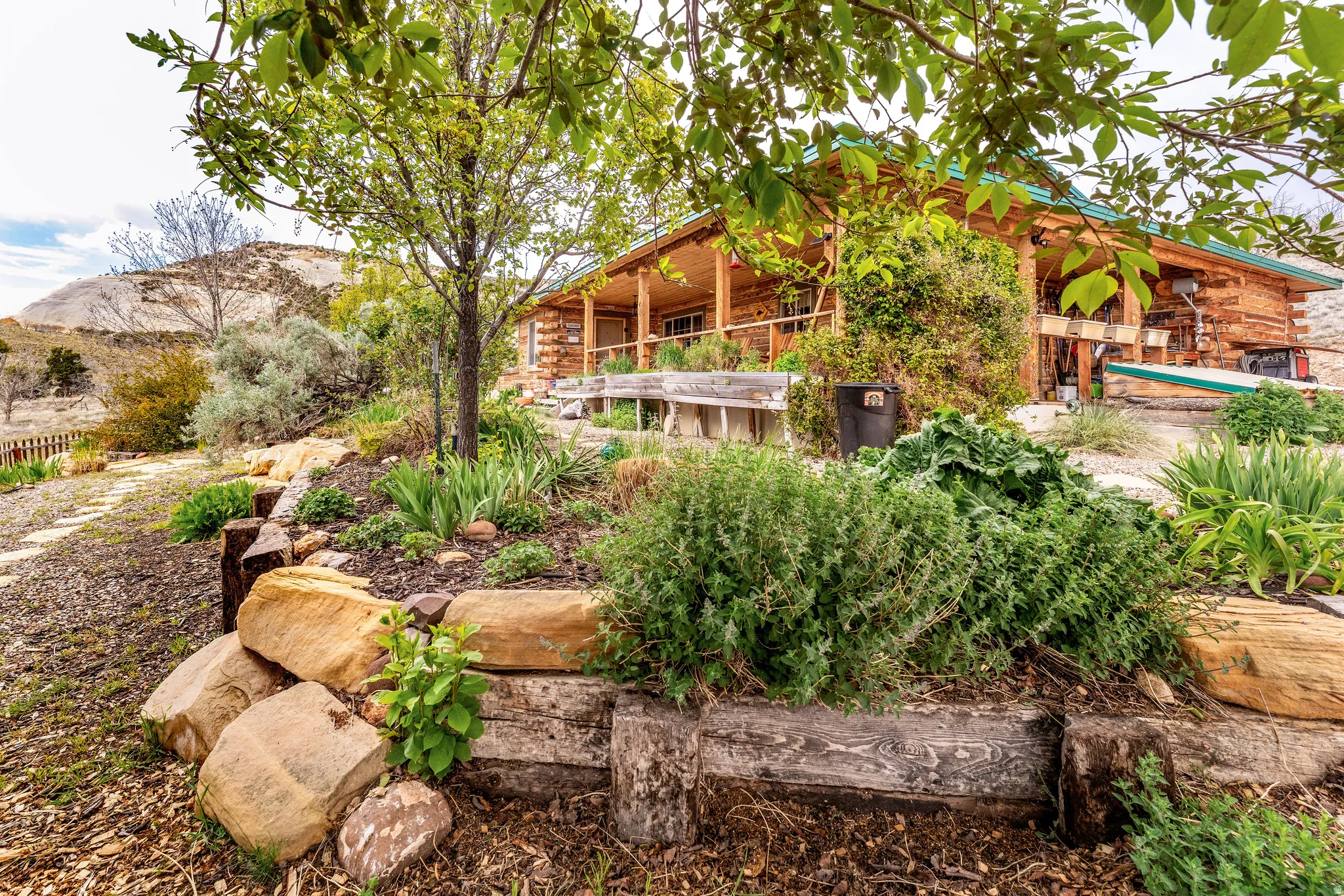 Log cabin exterior featuring a green roof and covered porch