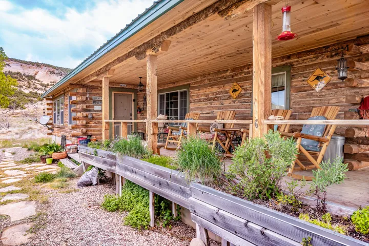 Expansive covered porch featuring a natural wood ceiling, log columns, and wood-finish railing