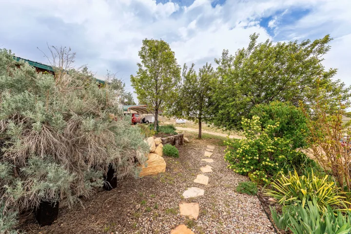 Landscaped pathway featuring flagstone pavers, mature trees, and diverse shrubbery