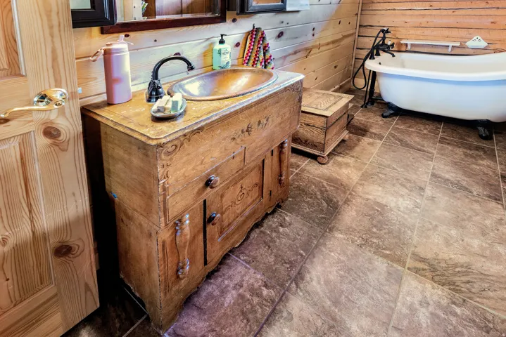 Antique wooden vanity with an integrated basin and dark-finish faucet