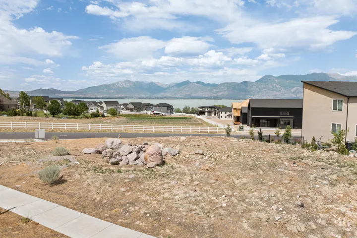 Expansive lot featuring a concrete sidewalk and a gravel driveway