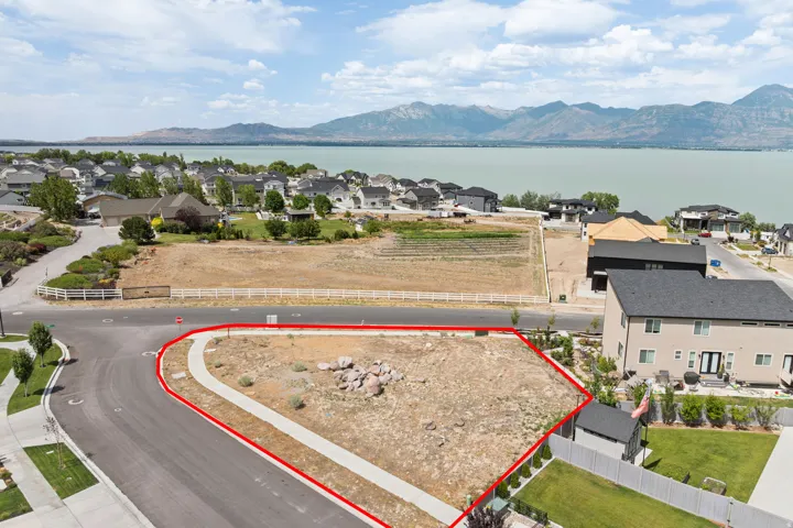Expansive corner lot featuring a partial concrete sidewalk