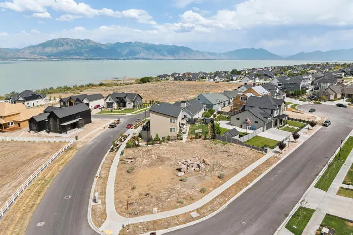 Residential lot featuring an established neighborhood setting, paved streets, sidewalks, and proximity to a large body of water with distant mountains