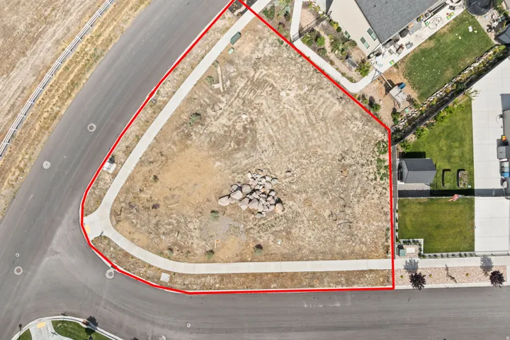 Vacant lot featuring a corner location, a paved road frontage, and a sidewalk along two sides