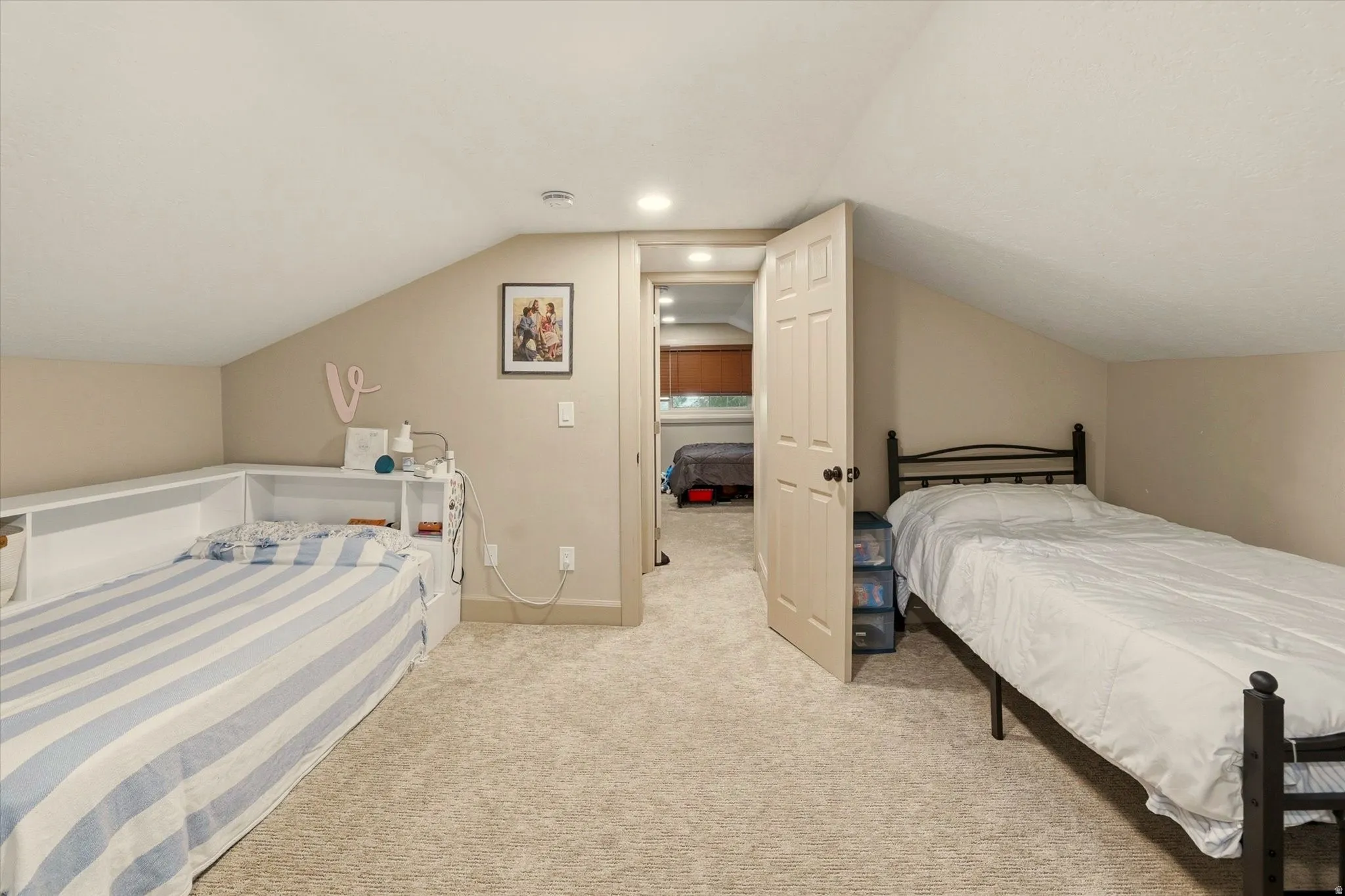 Carpeted room with sloped ceilings and built-in shelving
