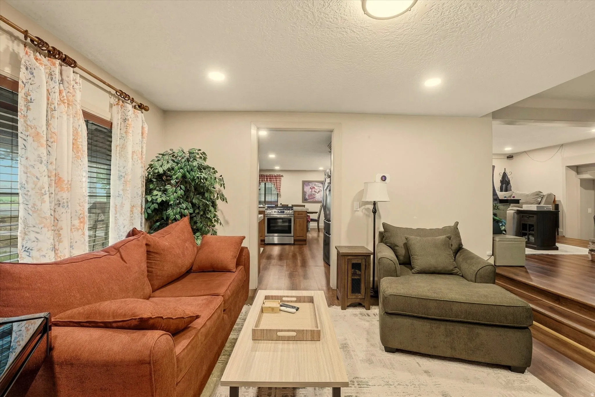 Living area featuring recessed lighting, large windows, and wood-finish flooring extending into adjacent spaces