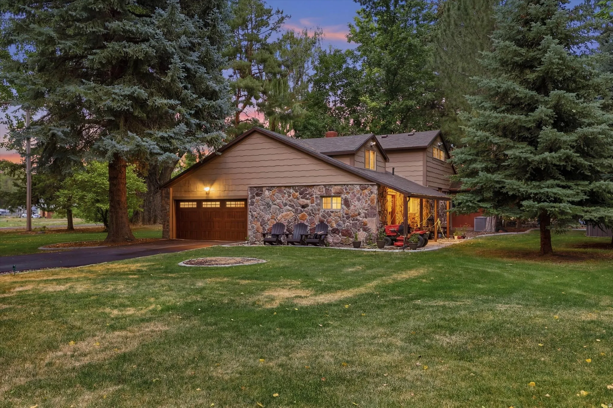 Stone and siding exterior with a two-car garage featuring a wood-panel door