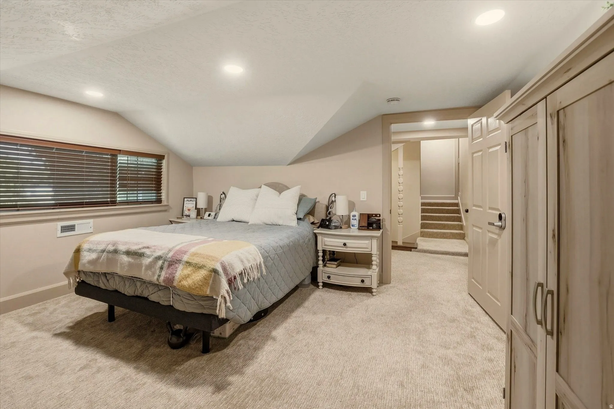 Carpeted room with recessed lighting and a window featuring horizontal blinds