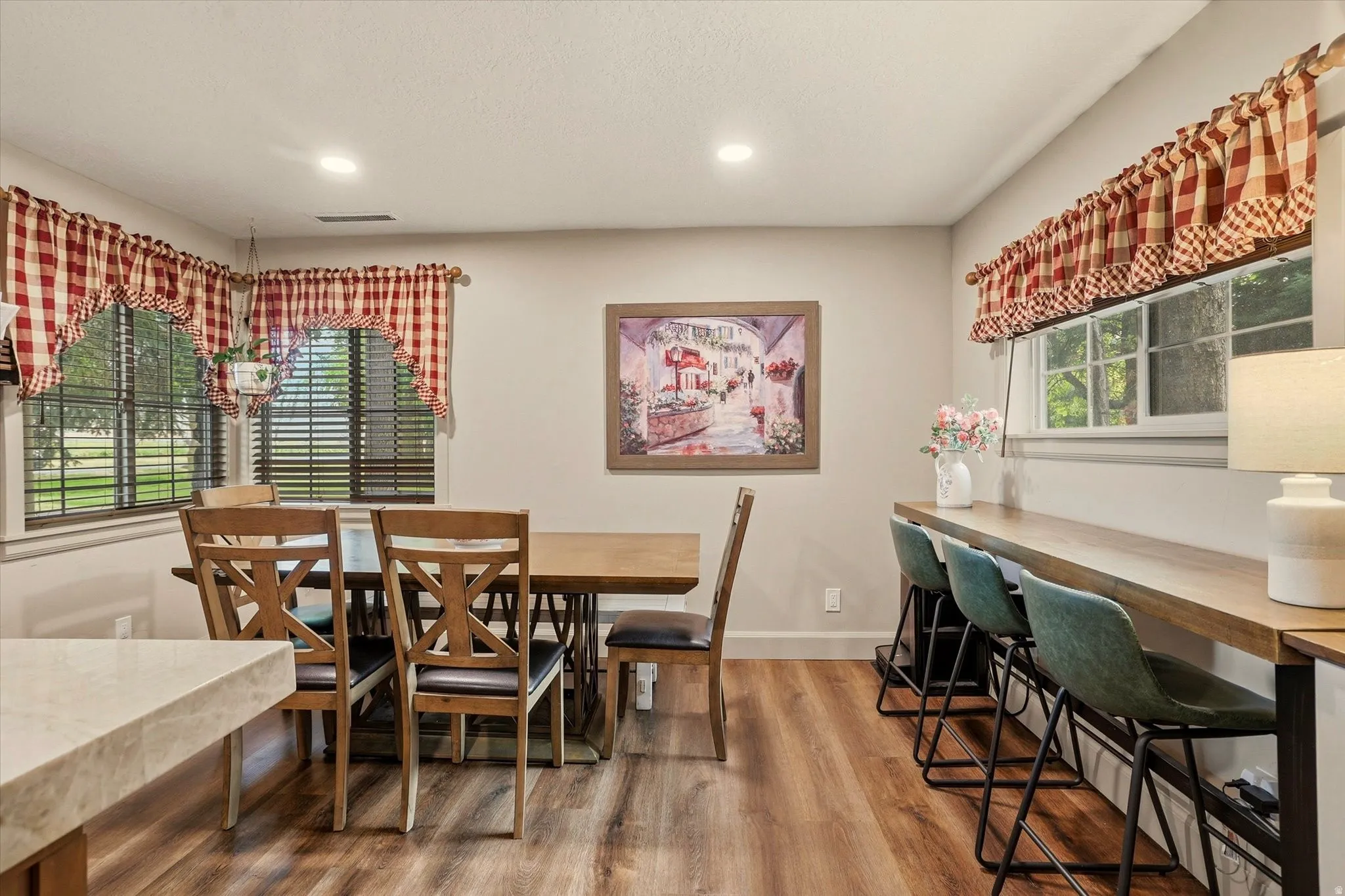 Dining area featuring wood-finish flooring, recessed lighting, and a built-in bar with bar seating