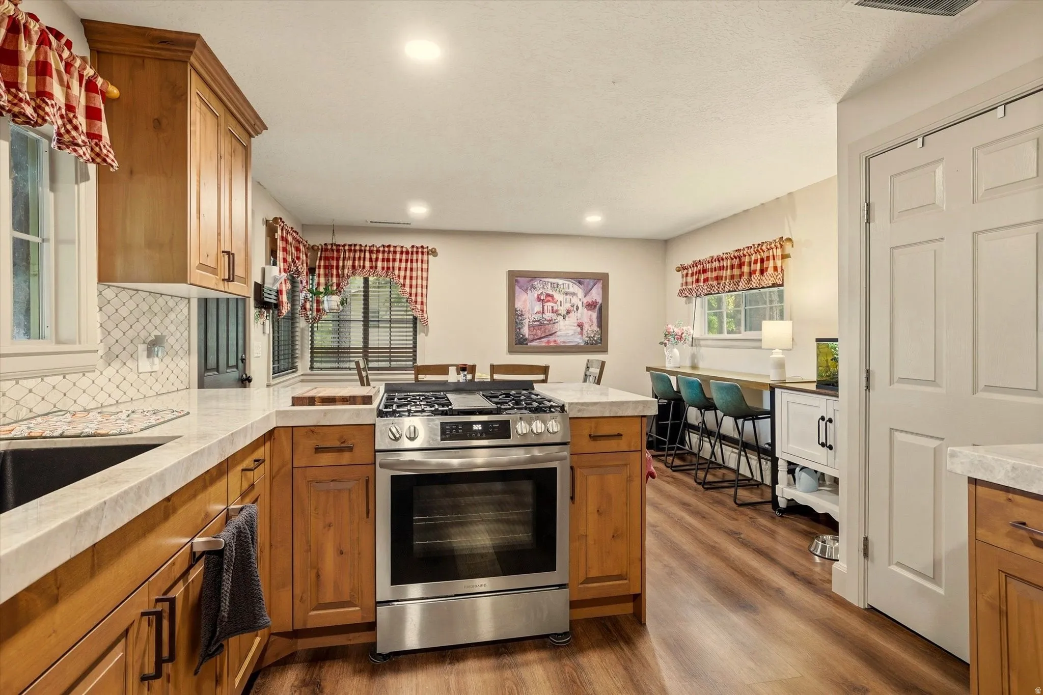 Kitchen featuring wood-finish flooring, recessed lighting, and light-toned cabinetry