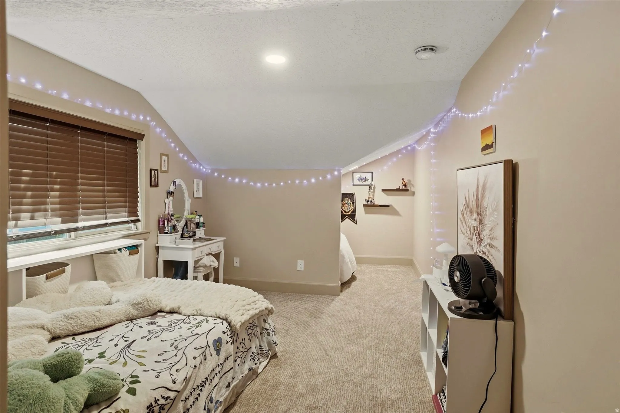 Carpeted room with sloped ceilings and recessed lighting