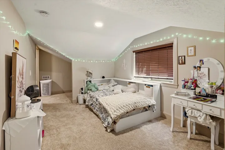 Carpeted room featuring a window with blinds, recessed lighting, and a built-in storage bench
