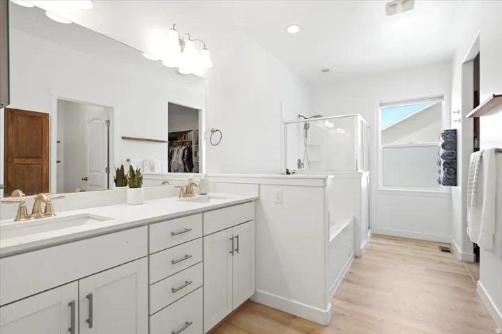 Modern bathroom featuring a double vanity with white cabinetry and light countertops