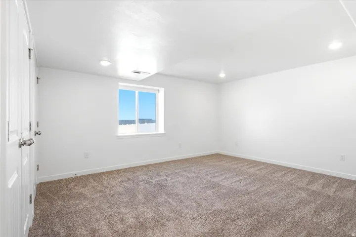 Recessed lighting, white walls, and a window with a white frame