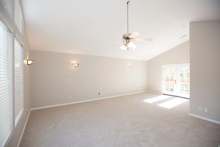 Spacious master suite featuring vaulted ceilings, light-colored carpeting, and neutral wall tones