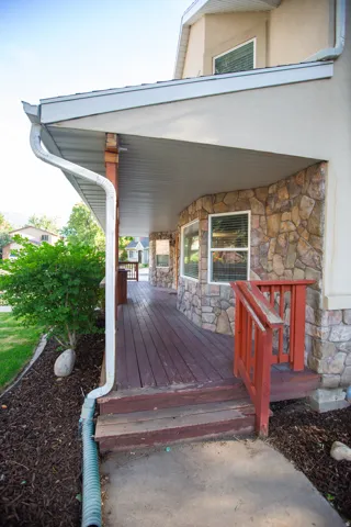 Covered front porch with stone facade accents and wood-finish decking