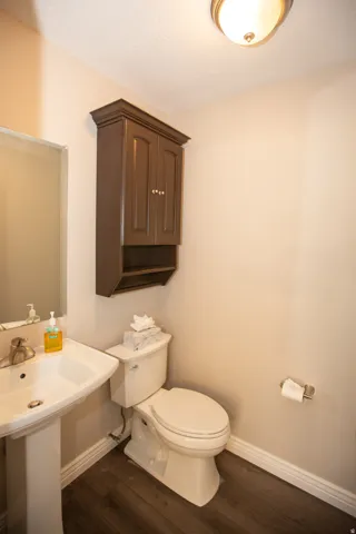 Half bath with pedestal sink with chrome faucet, complemented by a wall-mounted storage cabinet