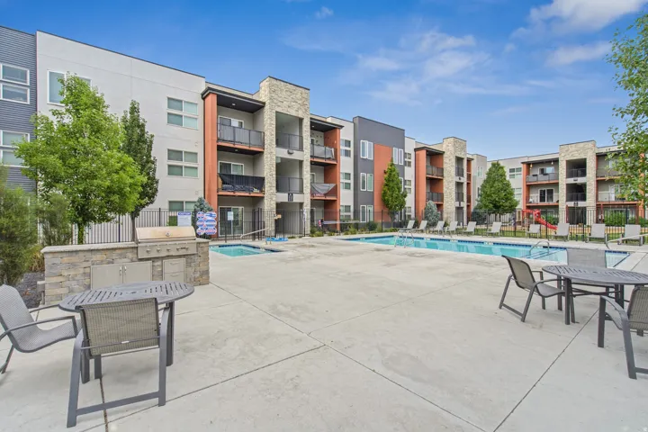 Outdoor amenity area featuring a swimming pool, separate spa, and built-in outdoor kitchen with grill