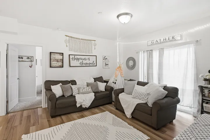 Spacious living area featuring wood-finish flooring, white walls, and a recessed ceiling light