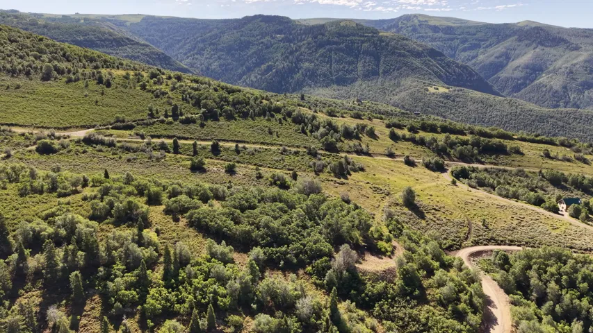 Expansive mountain terrain featuring lush green foliage and distant peaks